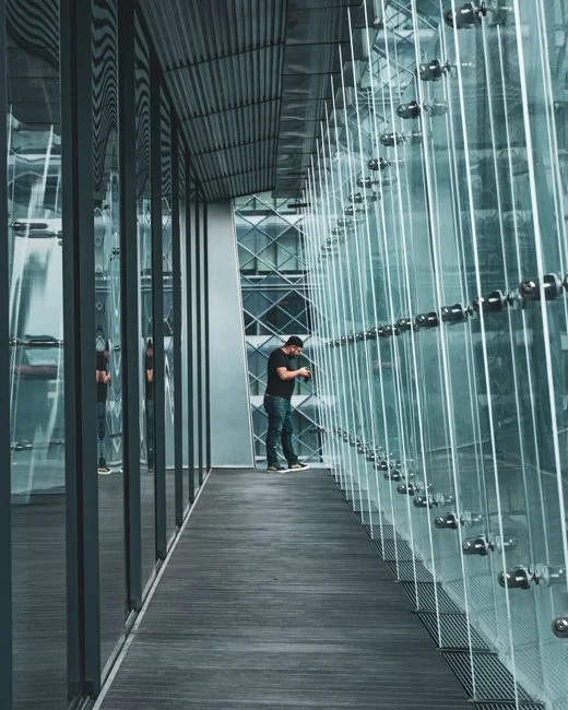 journey-01 A male window cleaner washing the exterior glass roof from above with a tool during daylight.